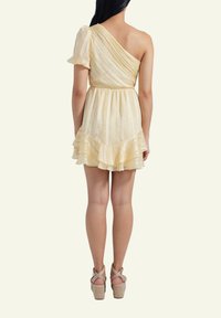 Gelbes, einseitiges Kleid mit schimmernder Textur, ausgestellt geschnittenem Saum und Rüschendetails. Verfügt über dekorative Nähte und eine taillierte Passform. Getragen mit Keilabsätzen.