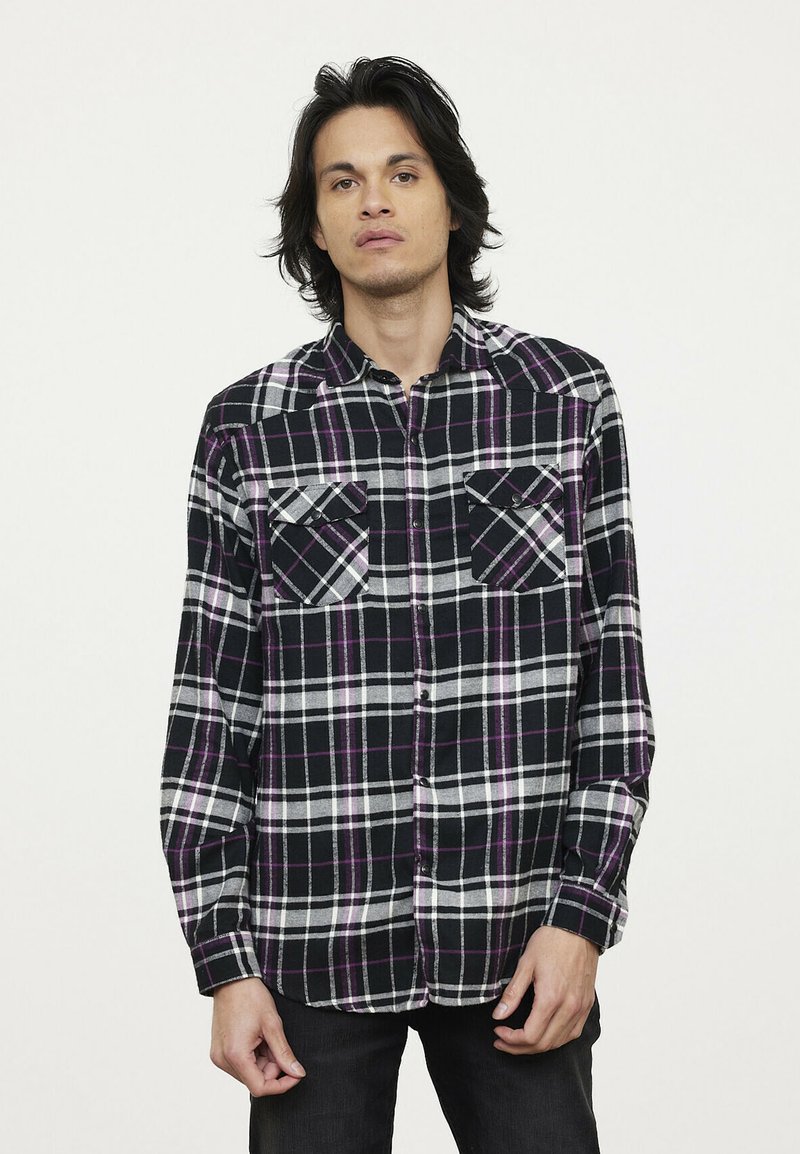Zwart-wit geruite flanellen shirt met paarse accenten, lange mouwen, knoopsluiting aan de voorkant en twee borstzakken. Zachte textuur.