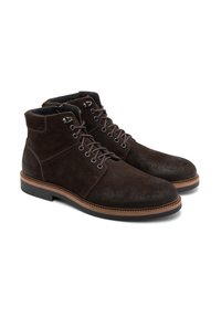 Brązowe zamszowe botki sięgające do kostki, z okrągłym noskiem, sznurowanym przodem, metalowymi oczkami sznurowadeł i beżowym przeszyciem na podeszwie. Miękka podszewka wewnętrzna.