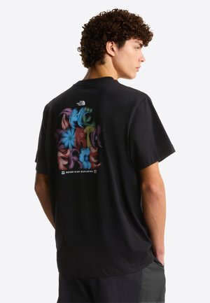 Schwarzes Baumwoll-T-Shirt mit einem bunten abstrakten Design auf der Rückseite und dem Schriftzug „NEVER STOP EXPLORING“ darunter. Kurze Ärmel, lockere Passform.