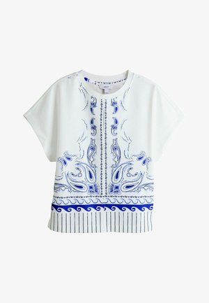 Biała bluzka z krótkim rękawem z niebieskim wzorem paisley i abstrakcyjnymi kwiatami, okrągły dekolt oraz pionowe paski wzdłuż brzegu.