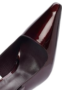 Zapatos de charol burdeos con punta afilada, laterales cortados y textura interior suave, con un acabado brillante que añade brillo.
