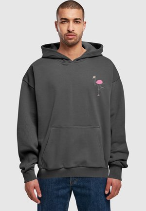Grå oversized hættetrøje med en frontlomme, der har et lille pink flamingo-tryk på venstre brystområde. Ribbet manchetter og kant.