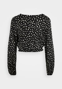Black cropped blouse with long sleeves, featuring a white spotted pattern and elasticated cuffs. Made from textured fabric with a wide neckline.