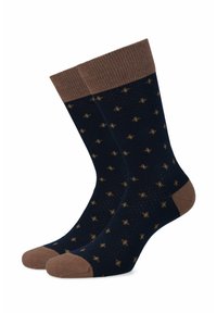 Granatowe skarpetki z brązowym prążkowanym mankietem i palcami. Ich powierzchnia zdobiona jest wzorem małych złotych gwiazd, wykonanym z miękkiego, teksturowanego materiału.