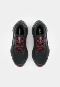 Încălțăminte sportivă neagră cu un superior texturat, șireturi roșii și branding Columbia. Dispune de o talpă căptușită pentru confort și suport.