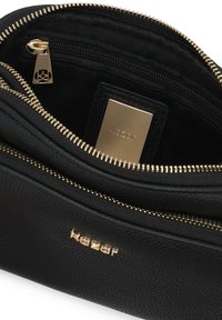 Fekete bőrtáska arany hardware-rel és cipzárokkal. Több rekesszel és sima felülettel rendelkezik. A márka logója belül látható.