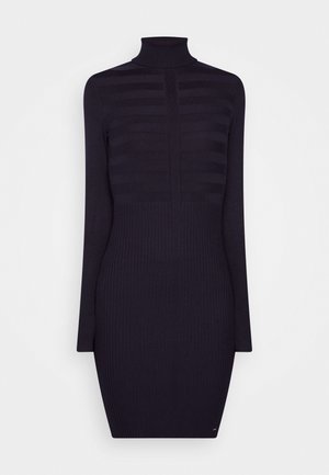 Gebreide coltrui-jurk in donker marineblauw, met ribbelstructuur en een horizontaal gestreept ontwerp, aansluitende silhouet en knielengte.