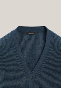 Niebieski prążkowany sweter-kardigan z dekoltem w serek i czarnym guzikiem, z metką Massimo Dutti po wewnętrznej stronie kołnierza.