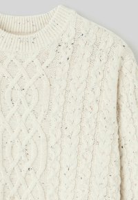 Pull en maille torsadée de couleur crème, présentant un design texturé avec un col rond côtelé classique et de subtils éclats de couleurs variés.