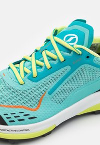 Scarpa da corsa azzurro chiaro con tomaia in rete, lacci gialli, accenti arancioni e suola ammortizzata. Presenta un logo distintivo sulla linguetta.
