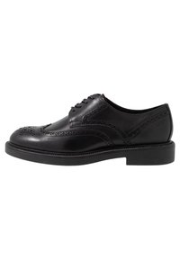 Chaussure habillée en cuir noir avec détails brogue perforés, bout rond, fermeture à lacets à cinq œillets et semelle en caoutchouc plate.