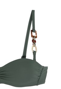 Zeleni bikinij top s nabranim detaljima, podesivim naramenicama i ukrasima u smešnim i krem bojama. Glatka tekstura, oblik s konturama.