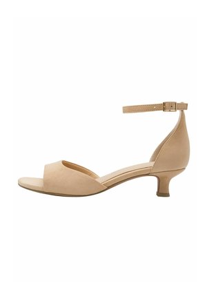 Nøgen beige ruskindssandal med åben tå og ankelrem. Lav blokhæl. Glat tekstur og enkelt design uden yderligere detaljer.