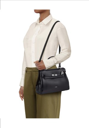 Schwarze Lederhandtasche mit strukturierter Form, silberner Hardware, Knebelverschluss und abnehmbarem Schulterriemen, gehalten von einer Person mit hellem Hemd.