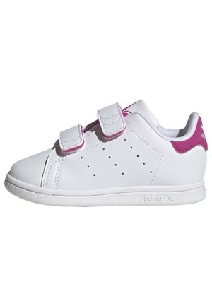 Baskets blanches Adidas avec deux bandes Velcro, côtés perforés et languette de talon rose avec logo, vues de côté gauche.
