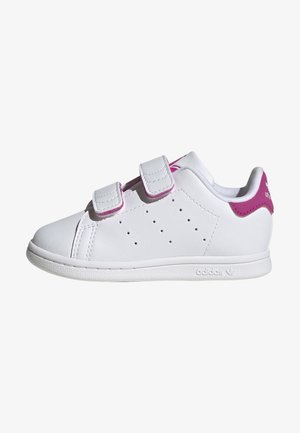 Baskets blanches Adidas avec deux bandes Velcro, côtés perforés et languette de talon rose avec logo, vues de côté gauche.