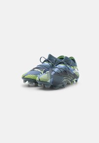 Scarpette da calcio in blu scuro e verde neon, con una parte superiore testurizzata, design leggero e tacchetti trasparenti per la trazione sull'erba.