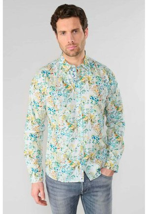 Floral shirt with a white base, featuring multicolored patterns of flowers and leaves. Button-up design with long sleeves and a collar.