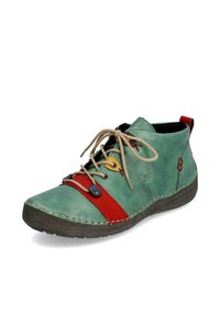 Chaussure en cuir vert avec des accents rouges et jaunes, dotée d'un bout rond, de détails cousus et de lacets neutres. Semelle en caoutchouc texturé, hauteur au niveau de la cheville.
