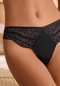 Black thong featuring a lace waistband with pink accents. The lace has a scalloped edge and a geometric pattern for added detail.