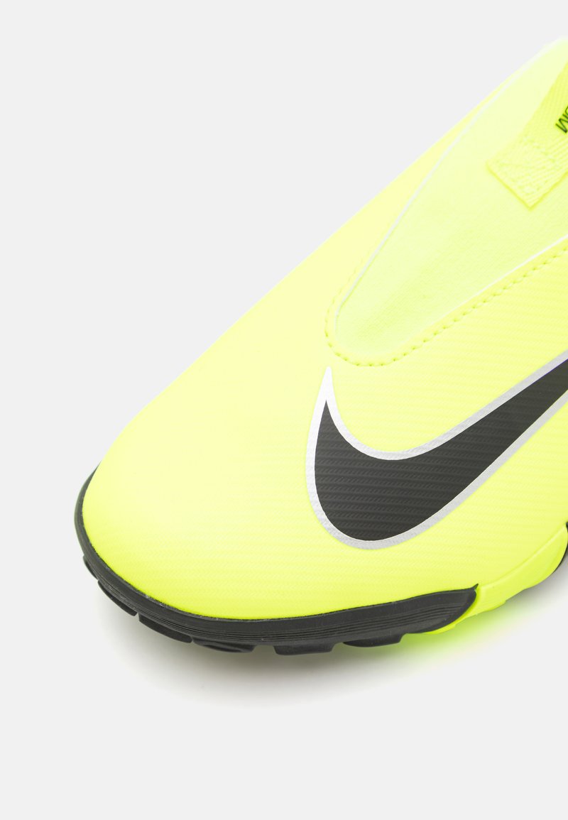 Helle gelbe Nike-Schuhe mit einem eleganten Design, schwarzen Akzenten und einer strukturierten Oberfläche. Verfügt über eine Schlupfbauweise und eine abgerundete Spitze.