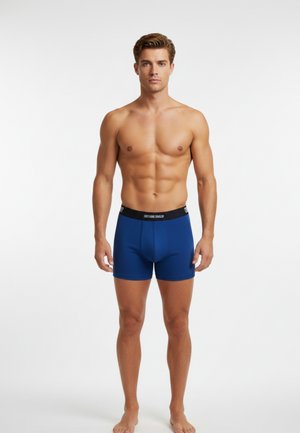 Blå boxershorts lavet af glat stof med en tætsiddende pasform, forsynet med et sort elastisk taljebånd med brandnavn, og en længde til midt på låret.