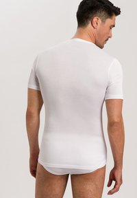 Weißes Kurzarmhemd aus glattem, enganliegendem Stoff, mit Rundhalsausschnitt und gerader Saum, von hinten an einem männlichen Model präsentiert.