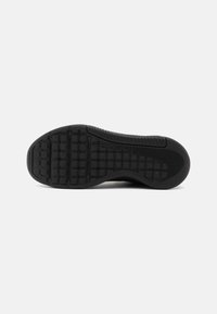 Suela de zapato de goma negra con patrón de agarre texturizado, que presenta cuadrados elevados y aristas para tracción y estabilidad. Bordes lisos, material duradero.