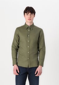 Olíva zöld gombos ing, hosszú ujjú, slim fit fazonú, puha anyagból készült. Kis logó található a mellkasán és klasszikus gallér kialakítása van.