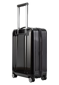 Valigia rigida nera con righe verticali, manico telescopico, ruote scorrevoli e chiusura a zip. Materiale plastico durevole.