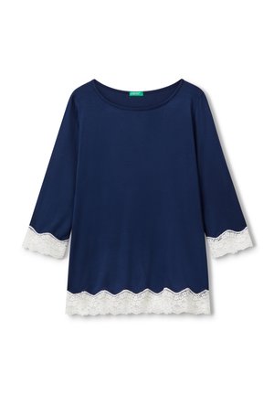 Top blu navy con maniche a tre quarti, caratterizzato da un bordo di pizzo bianco a scallopato sull'orlo e sui polsini. Tessuto morbido e liscio.