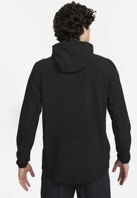 Zwarte capuchonjas met lange mouwen, een gladde textuur en een iets langere zoom aan de achterkant. Voorzien van elastische manchetten en een minimalistisch ontwerp.