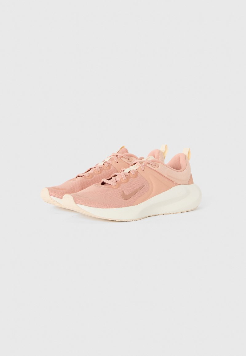 Zapatillas deportivas de color rosa claro, hechas de malla transpirable con acentos texturizados, que cuentan con una suela acolchada y un discreto detalle de logo.