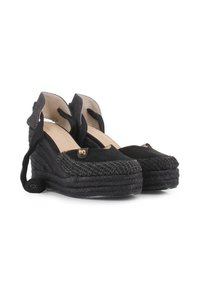 Zapatos de cuña espadrille negros con un upper de tela texturizada, detalles en piel, cintas en el tobillo y una suela de cuerda trenzada.