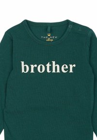 Groene katoen lange mouwen shirt met het woord "brother" in grote crèmekleurige letters. Inclusief een ronde hals en drukknoopsluiting op de schouders.