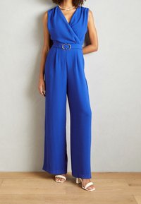Kungsblå jumpsuit med en insvept överdel, vida ben, ett bälte i midjan med en rektangulär spänne och slät, texturerad tyg.