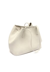 Witte leren tas met een gestructureerd oppervlak, slungelig ontwerp, twee handvatten en een open bovenkant. Minimalistische stijl zonder zichtbare hardware of accenten.
