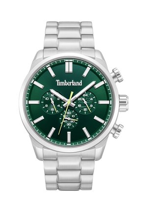 Srebrna kovinska zapestna ura s temno zelenim številčnikom, belimi urami, tremi dodatnimi številčnicami, rumeno sekundno ročico in logotipom Timberland na sredini.