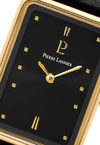 Melns kvadrāts pulksteņa ciparnīca ar zelta akcentiem. Iezīmē minimālistiskus stundu rādītājus un rādītājus, zīmola nosaukums "Pierre Lannier" ir redzams.