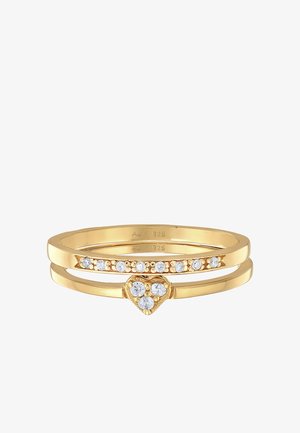 Sæt af ringe i guld-tone bestående af tre bånd: ét med et hjerteformet accent og to med klare, funkende sten. Justerbart design, glat finish.