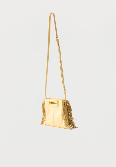 Petit sac bandoulière en cuir beige avec longue bandoulière réglable et détails de franges des deux côtés, isolé sur un fond clair.