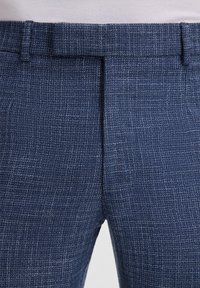 Pantaloni blu a fantasia con una trama strutturata, dotati di frontale liscio, passanti per cintura e una finitura pulita in vita.