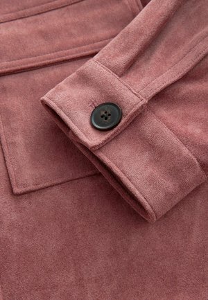 Pink suede jacket sleeve with a black button detail. Features a smooth texture and clean stitching, highlighting the fabric's softness.
