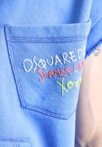 Hemd aus blauem Stoff mit einer Brusttasche und mehrfarbig gesticktem Text: "DSQUARED2 SUMMER LOVE XOXO." Weicher Stoff mit genähten Kanten.