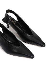 Czarne skórzane sandały na obcasie z wąskim noskiem, elastycznym tyłem i małym obcasem w kształcie stożka. Gładka tekstura i minimalistyczny design.