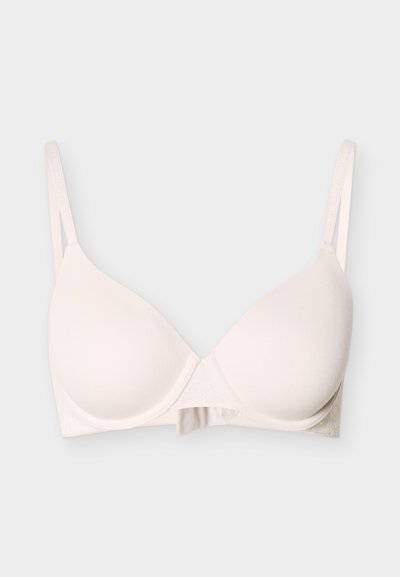 Ανοιχτό μπεζ επενδεδυμένο σουτιέν με ρυθμιζόμενους λεπτούς ιμάντες ώμων και ενίσχυση με μπανέλα, παρουσιασμένο σε απλό φόντο.