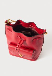 Borsa a secchiello in pelle rossa con bordo superiore ondulato, chiusura a coulisse, ferrature dorate e tasca esterna frontale con fermaglio. Interno marrone.