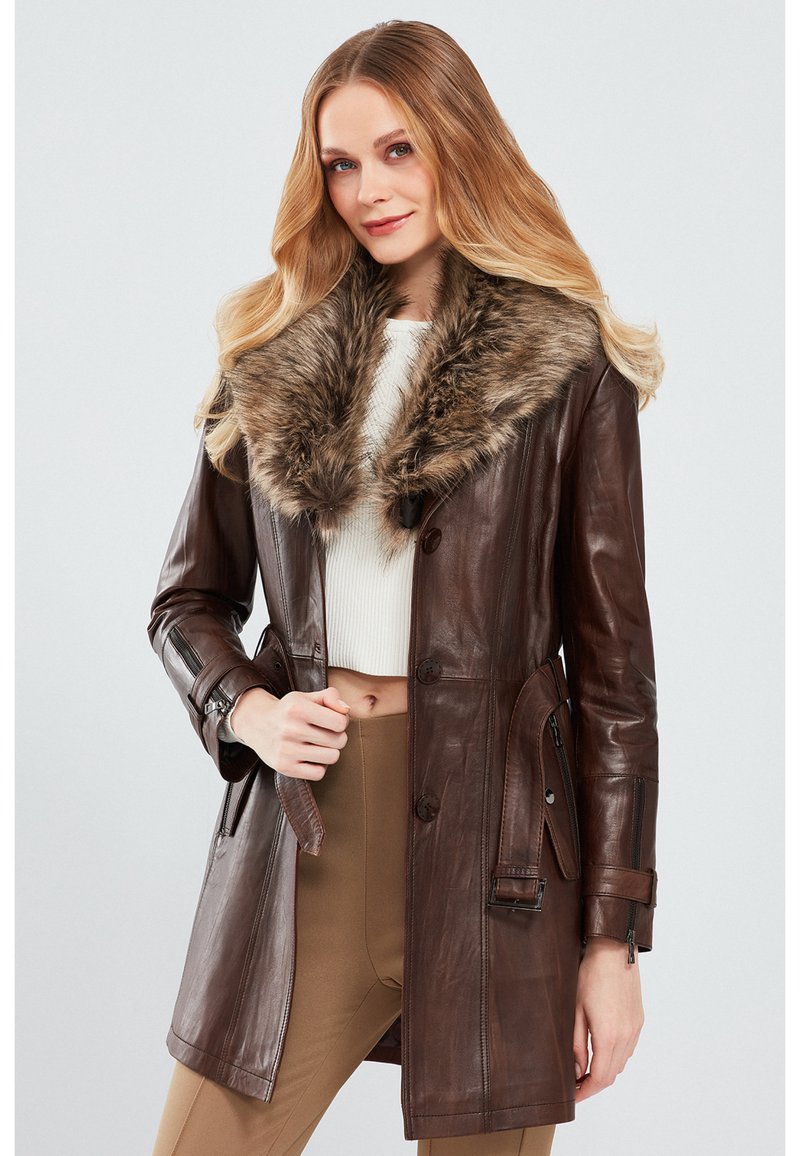 Brown leather coat with a fur collar, featuring button closure, side pockets, and an adjustable waist. Smooth texture and tailored design.