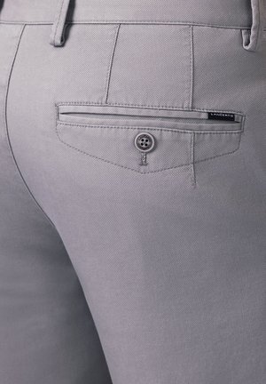 Szare spodnie z teksturowanej tkaniny, tylna kieszeń z zapięciem na guzik oraz mała metka z logo.